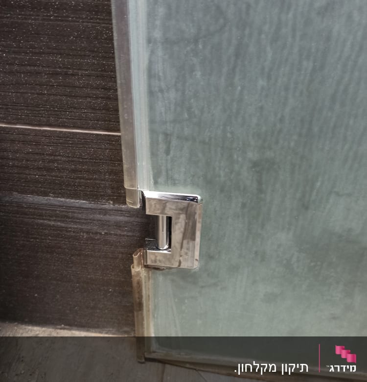 ציר מתכת על דלת זכוכית במקלחת